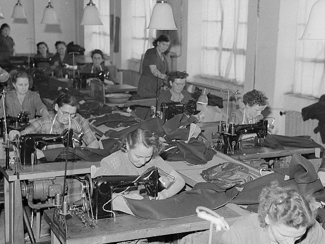 Szakember a frissen elkészült munkaruhát ellenőrzi a varrodai műhelyben